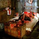 Keine Texte vorhanden. Ein düsterer Raum mit einem unordentlichen, blutverschmierten Bett und einem offenen Holzsarg.