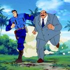 Zwei Männer rennen; einer im blauen Kampfanzug, der andere im grauen Anzug. Palmen im Hintergrund, helle Umgebung.