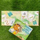 Auf einer grünen Wiese liegen zwei Bücher. Eines zeigt "SPARROW LOVES REPTILES" in großer blauer Schrift.