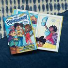 Comic-Cover: "The Brainstormerz: Money Talks". Drei fröhliche Kinder. Geöffnetes Buch zeigt bunte Comics.