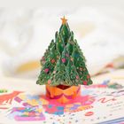 Im Vordergrund steht ein kunstvoller, aufklappbarer Weihnachtsbaum mit bunten Verzierungen auf einer Seite voller Geschenke.