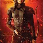Texte: „THE WORLD OF THE HUNGER GAMES“, „Nobody decent ever wins the Games“. Frau in Rüstung mit Bogen.