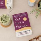 Covertext: "Not Just a Period." von Dr. Hazel Wallace. Daneben liegen ein grünes Getränk, eine Brille, eine Kerze und eine Pflanze.