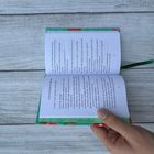 Ein geöffnetes Buch mit einem Gedicht, das Titel enthält wie "from Craving for Spring". Eine Hand hält das Buch.