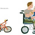 „Dad wipes away tears.“ Ein Mann im Rollstuhl hält ein Kind; ein rotes Fahrrad steht daneben.