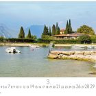 "Val di Sogno" und "CASARES EDITION". Ufer mit Booten, Pinien, Häusern und Bergen im Hintergrund.