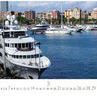 "Port Vell", Zahlen 1-31 unten, auffällige Yachten im Hafen, bunte Gebäude im Hintergrund, blauer Himmel.