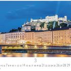 "Salzburg" über einem Fluss und beleuchteten Gebäuden mit einer Burg im Hintergrund. Darunter Kalenderdaten.