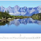 "Österreich, Spiegelsee." Klare Berglandschaft mit See, Bäumen und Bergen im Hintergrund. Kalender mit Monatsübersicht.