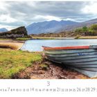 "Killarney Lake in Co. Kerry", ein See mit Booten, Bergen im Hintergrund, grasbewachsene Ufer. Kalender mit März-Daten unten.