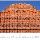 "Jaipur, Palast der Winde" steht unter einem prächtigen, rosa Sandstein-Gebäude mit vielen Fenstern und kunstvollen Verzierungen.