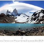 Mount Fitz Roy, El Chaltén. Kalenderseite März. Schneebedeckte Berge, blauer Himmel, türkiser See im Vordergrund.