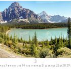 Nationalpark Banff, Monatszahl 3. Ein See mit türkisfarbenem Wasser, umgeben von Nadelbäumen und Bergen im Hintergrund.