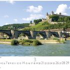 "Würzburg Feste Marienberg" und der Monat März sind zu sehen. Eine alte Steinbrücke mit Statuen vor einer Festung.