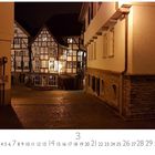 Mülheim, Altstadt. März Kalenderseite. Fachwerkhäuser erleuchtet in einer gepflasterten Gasse bei Nacht.