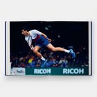 Texte: "FedEx" und "RICOH". Ein Tennis-Spieler springt dynamisch in blauer Sportkleidung, hält einen Schläger.