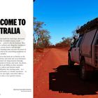 "Welcome to Australia" steht groß. Ein Geländewagen fährt auf einer roten, staubigen Straße, umgeben von spärlichen Bäumen.