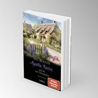 Buchtitel: "Agatha Raisin und die tote Therapeutin" von M.C. Beaton. Ein idyllisches Dorfhaus mit Garten im Hintergrund.