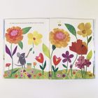 Ein kleines Tier bemalt bunte Blumen auf einem Feld. Eine Biene fliegt zwischen den großen, farbenfrohen Blüten.