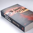 "Dora Heldt. WIR SIND die GUTEN. Karl Sönnigsens zweiter Fall." Buch mit Landschaftsbild auf dem Cover.