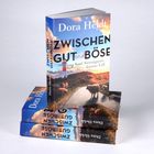 Buchtitel: "Zwischen Gut und Böse" von Dora Heldt. Cover zeigt eine Landschaft mit Schafen und einem Leuchtturm.