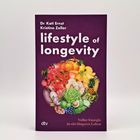 „Lifestyle of Longevity“ von Dr. Kati Ernst, Kristine Zeller. Obst- und Gemüse-Illustration auf lila Hintergrund.