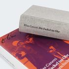 Der Buchrücken zeigt den Text: "Elias Canetti Die Fackel im Ohr". Ein Buch liegt auf einem anderen mit einem verschwommenen Bild.