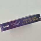 Buchtitel: "Weihnachtszauber in der kleinen Büchervilla" von Annette Keller. Verlag "Piper". Blau-lila Gestaltung mit Schneeflocken.