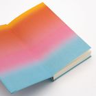 Buchcover-Innenseite mit Farbverlauf von Orange über Pink zu Blau.