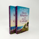 Zwei Bücher von H.C. Hope mit dem Titel "Herzklopfen im kleinen Cottage". Cover zeigt Küstenlandschaft.
