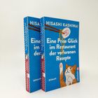 Zwei blaue Bücher: "Eine Prise Glück im Restaurant der verlorenen Rezepte" von Hisashi Kashiwai. Mit Katze und Logo.