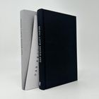 Zwei Bücher mit der Aufschrift "DAS WEISSE BLATT PAPIER" auf dem Rücken. Ein Buch ist grau, das andere schwarz.