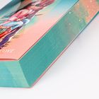 Der Text lautet "COVE". Zu sehen ist ein Buch mit türkisfarbenen Seiten und einem farbenfrohen Cover.