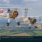 "Bücker Jungmeister ▪ Schulflugzeug ▪ 1935–1941 ▪ Motor: Siemens-Halske Sh 14A." Drei Doppeldecker fliegen über Felder.