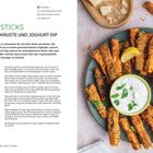 ZUCCHINI-STICKS MIT PARMESAN-KRUSTE UND JOGHURT-DIP. Zucchini-Sticks auf einem Teller, serviert mit Dip und Zitronenscheibe.