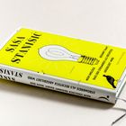 Buchtitel: "Mein Unglück, dass der Stromkreis als Rechteck abgebildet wird", gelber Einband mit Glühbirnenillustration.