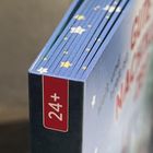 "24+" auf rotem Streifen. Buchrücken mit blauen Seiten, Sternenmuster und teilweise sichtbarem Titel in Rot.