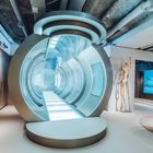 Leuchtender futuristischer Tunnel im Inneren, mit einer Holzskulptur links und modernen Möbeln rechts.