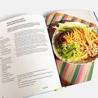 "Kalte Sesamnudeln mit Gurke & Erdnuss" steht oben. Daneben ein Teller mit Nudeln, Gurkenstreifen und Erdnüssen auf bunter Matte.