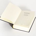 "Der Koran", Übersetzung von Max Henning, Verlag: Anaconda. Offenes Buch auf weißem Hintergrund.