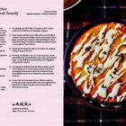 Rezept für "Spätsommerlicher Feigenkuchen mit Brandy". Kuchen mit heller Glasur und frischen Kräutern auf dunklem Teller.