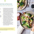 "Brokkoli-Salat mit Räuchertofu" Rezept und Bild des Salats auf einem Teller, verziert mit roten Zwiebelringen und Tofu-Würfeln.