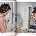 Ein offenes Buch zeigt einen Mann im weißen Tanktop vor einem Spiegel, der sich sein Gesicht abtrocknet. Links steht "Ajax".