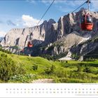 "märz" und ein Kalendarium. Berglandschaft mit roten Seilbahngondeln vor steilen Felswänden, grünen Wiesen und klarem Himmel.