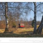 Text: "März", "Der 1933 in Dessau gebaute Triebwagen 187 001." Landschaft mit Birken und rotem Zugzug im Hintergrund, blauer Himmel.