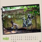 Text: "WE'RE ALL IN THE SAME BOAT" und "MÄR". Eine Wandmalerei zeigt Menschen in einem Boot vor einer Ziegelwand.