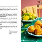"Arancini" und Rezept für frittierte Reisbällchen. Rechts ein Teller mit Arancini, Schale mit Oliven, Zitrusfrüchte im Hintergrund.