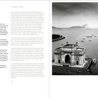 „The Gateway to New Life“ und „Living the Dream“. Schwarz-weißes Foto von einem Torbogen am Wasser mit Booten und Inseln.