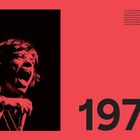 Großer schwarzer Text "1973" auf rotem Hintergrund. Links daneben singt leidenschaftlich eine Person mit Mikrofon.