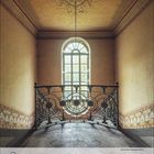 Kalenderseite: März 2027, mit Zahlen und Daten. Ein verziertes Treppenhaus mit einem großen, halbkreisförmigen Fenster.